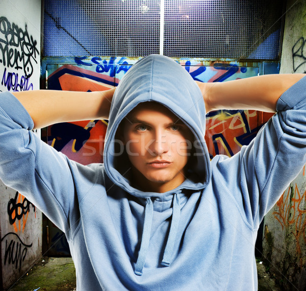 Stock photo: Cool looking hooligan in a graffiti painted gateway