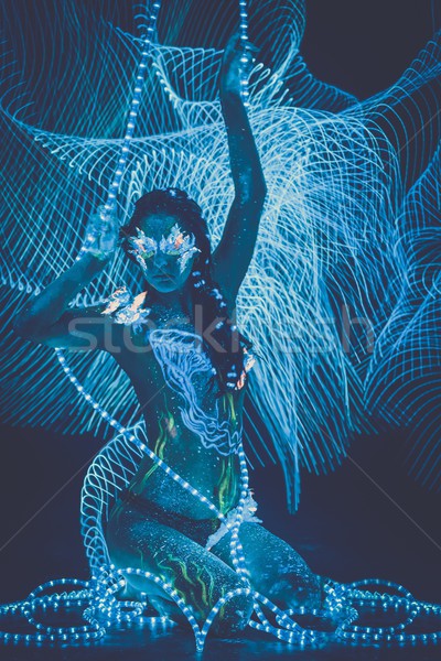 Beautiful woman with body art glowing in ultraviolet light and freezelight background Stock photo © Nejron
