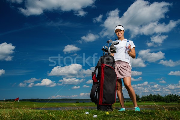 Young cheerful woman with bag and bottle of water on a golf field Stock photo © Nejron