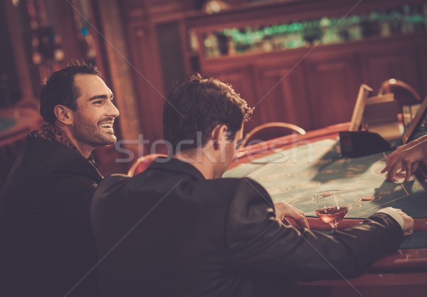 Two fashionable men in suits behind table in a casino Stock photo © Nejron