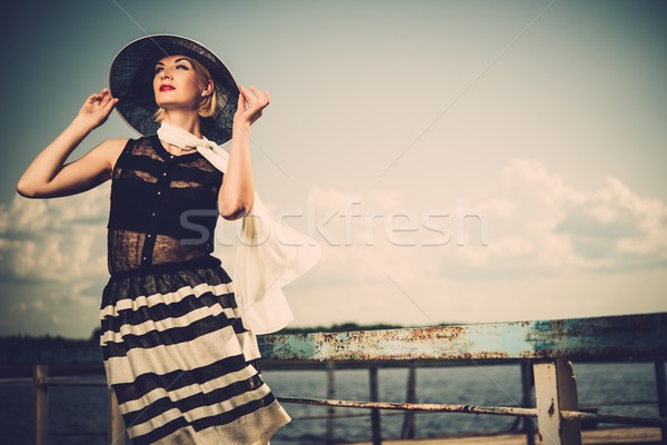 Woman in white hat and scarf standing near old pier rails  Stock photo © Nejron
