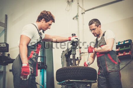 Serviceman unscrewing wheel in car workshop  Stock photo © Nejron