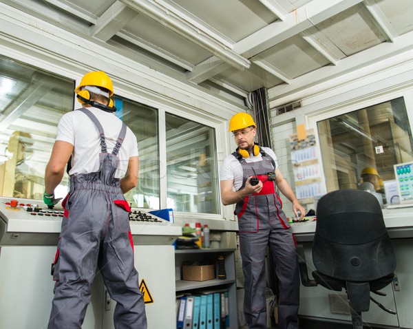 Two operators wearing safety hat in a factory control room Stock photo © Nejron