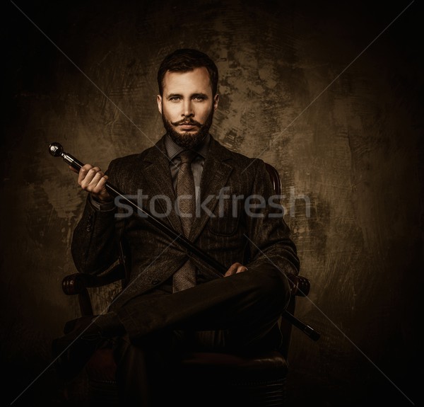 Handsome well-dressed man with walking stick sitting in leather chair  Stock photo © Nejron