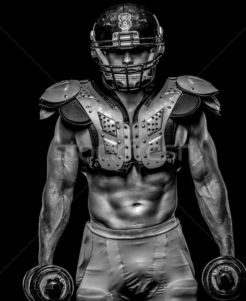 Stock photo: American football player with dumbbells wearing helmet and protective armour 