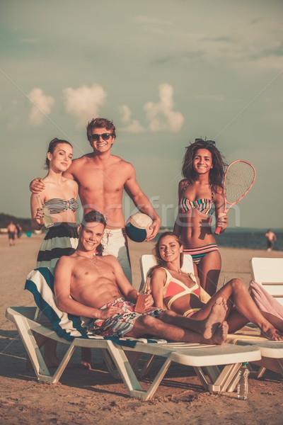 Group of multi ethnic friends with ball and racket on a beach  Stock photo © Nejron