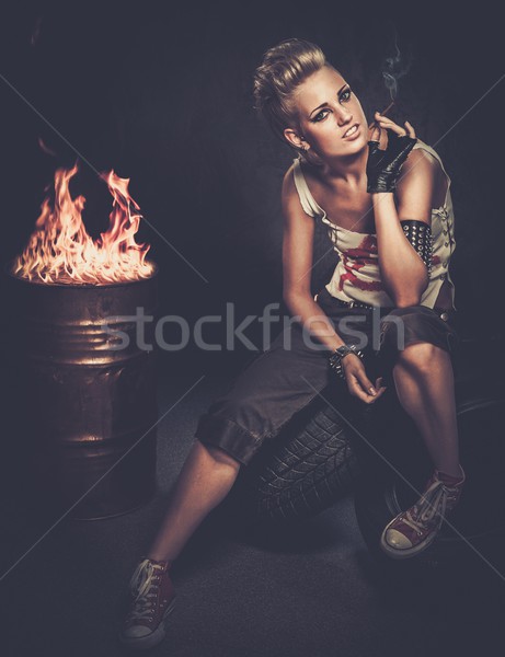 Punk girl smoking a cigarette sitting on a tires  Stock photo © Nejron