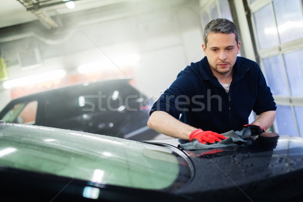 Cheerful worker wiping car on a car wash Stock photo © Nejron