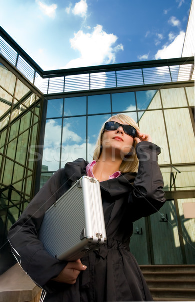 Beautiful young woman with silver case near the modern office bu Stock photo © Nejron