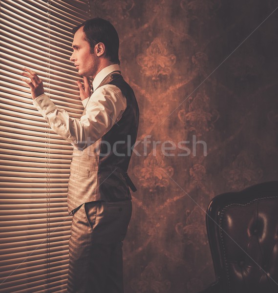 Well-dressed man looking through jalousie  Stock photo © Nejron