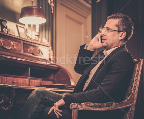 Confident middle-aged man with mobile phone in luxury interior  Stock photo © Nejron