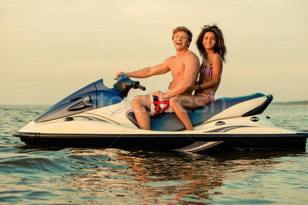 Multi ethnic couple sitting on a jet ski Stock photo © Nejron