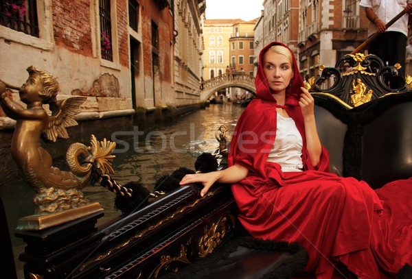 Gyönyörű nő piros köpeny lovaglás épület város Stock fotó © Nejron