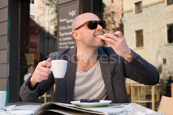 MIddle-aged man enjoying coffee with piece of cake in street cafe Stock photo © Nejron