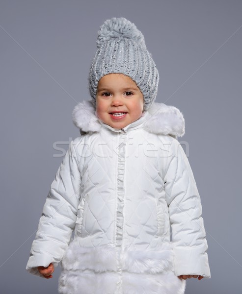 Funny little girl in winter coat isolated on grey Stock photo © Nejron