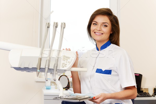 Young brunette woman dentist with dental tools in dentist's surgery Stock photo © Nejron