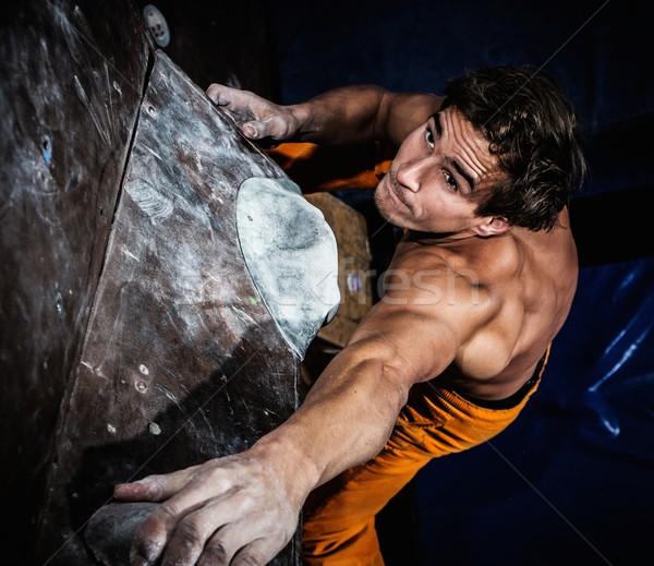 Muscular man practicing rock-climbing on a rock wall indoors  Stock photo © Nejron