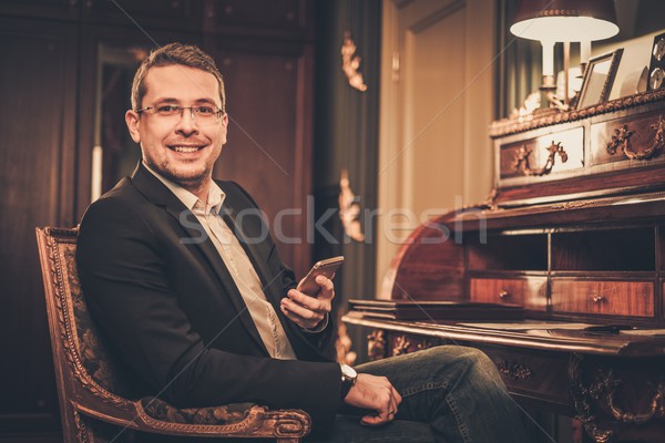 Confident middle-aged man with mobile phone in luxury interior  Stock photo © Nejron