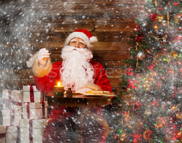 Stock photo: Santa Claus in wooden home interior sitting behind table and writing letters with quill pen