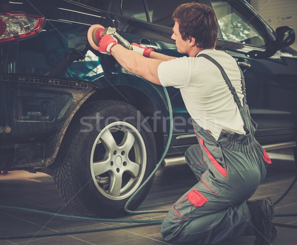 Serviceman polishing car body with machine  in a workshop Stock photo © Nejron