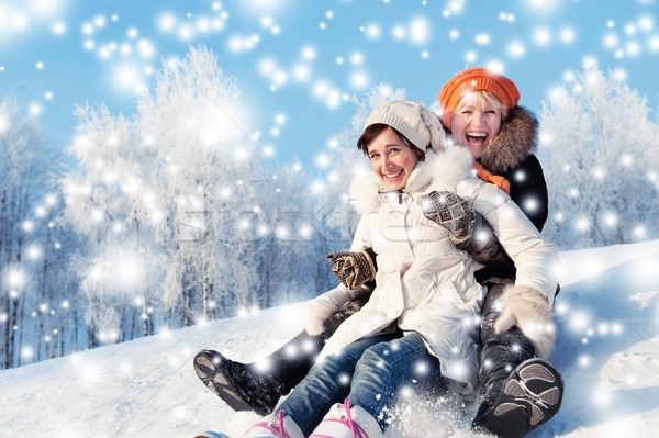 Mother and daughter sliding in the snow  Stock photo © Nejron