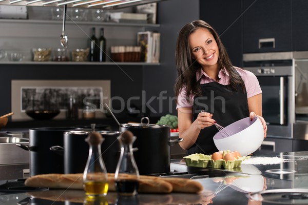 Jeune femme tablier oeufs modernes cuisine oeuf Photo stock © Nejron