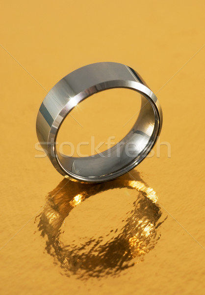 Silver ring reflected in golden surface Stock photo © Nejron