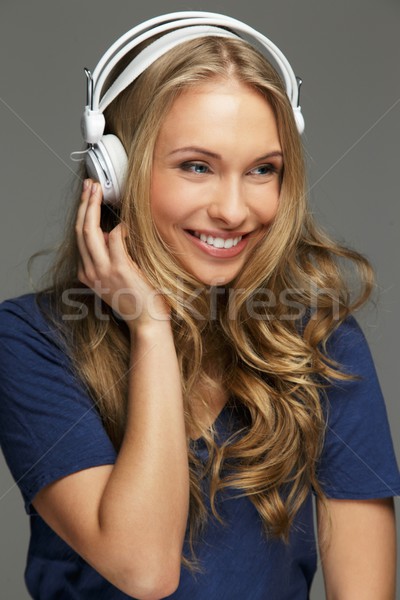 positive young woman with long hair and blue eyes listens to