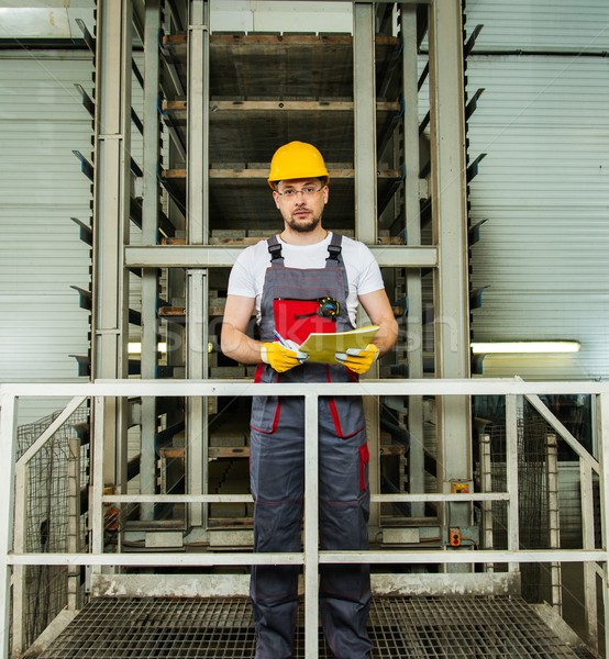 Man in a safety hat taking notes on a factory   Stock photo © Nejron