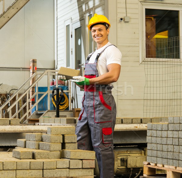 Young worker near conveyor belt with paving stone  on a factory   Stock photo © Nejron