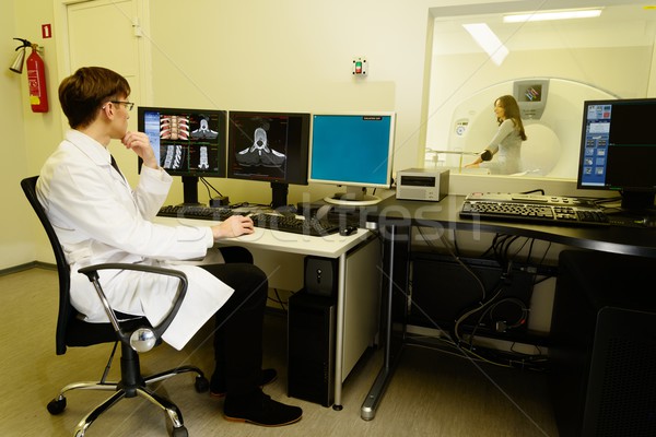 Young doctor sitting behind monitors in a computed tomography laboratory  Stock photo © Nejron