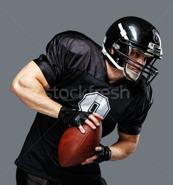 Stock photo: American football player with ball wearing helmet and jersey 