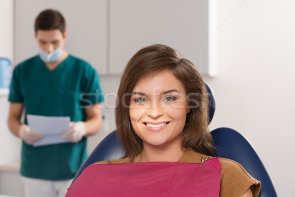 Male dentist reading female patient's card Stock photo © Nejron