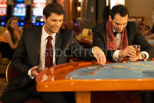 Two young well-dressed men behind gambling table in a casino Stock photo © Nejron