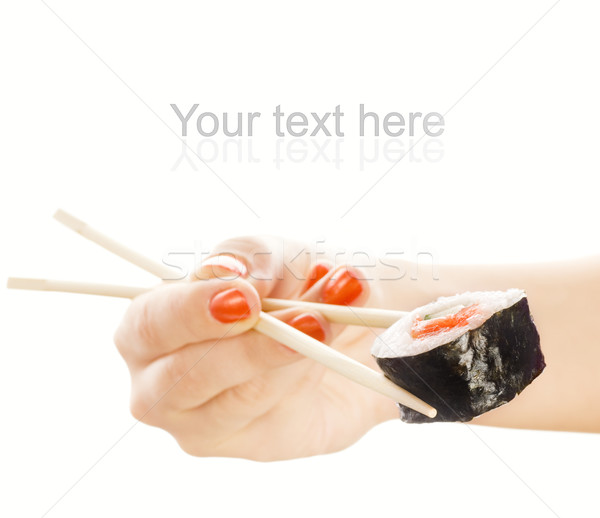 Hand holding sushi maki with wooden chopsticks (shallow DoF, foc Stock photo © Nejron