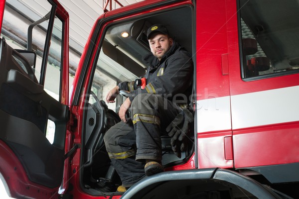 Fireman behind steering wheel of a firefighting truck  Stock photo © Nejron