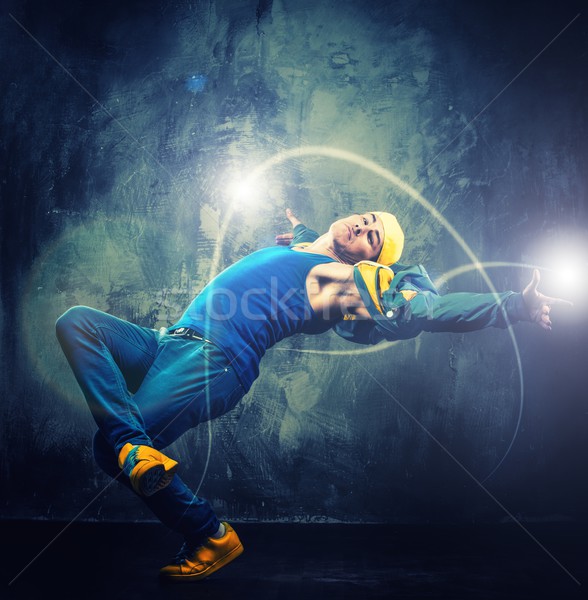 Stylish man dancer showing break-dancing moves with magic beams around him  Stock photo © Nejron