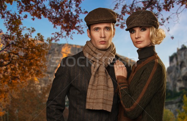 Elegant couple in caps against autumnal landscape Stock photo © Nejron