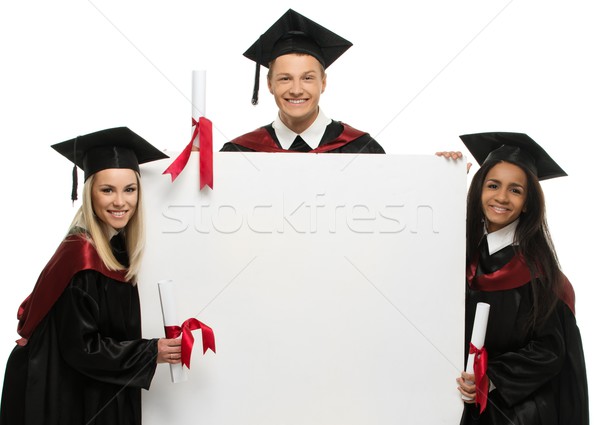 Multi ethnic group of graduated young students with blank notice board Stock photo © Nejron
