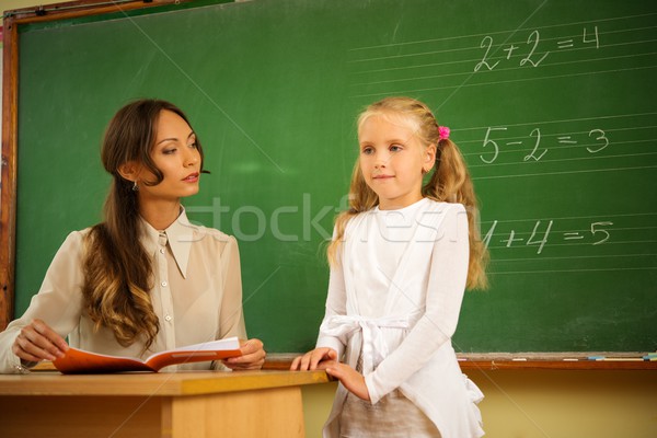 Little schoolgirl answering near blackboard in school Stock photo © Nejron