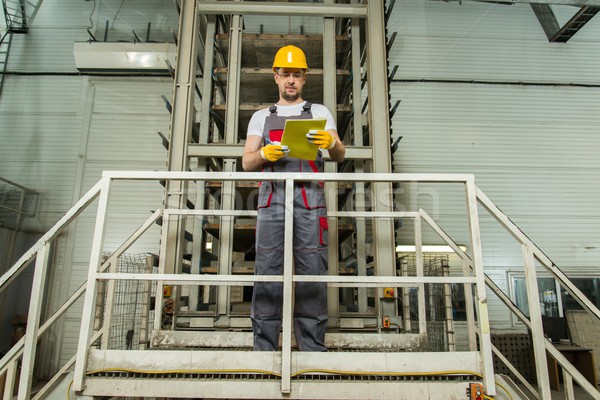 Man in a safety hat taking notes on a factory   Stock photo © Nejron