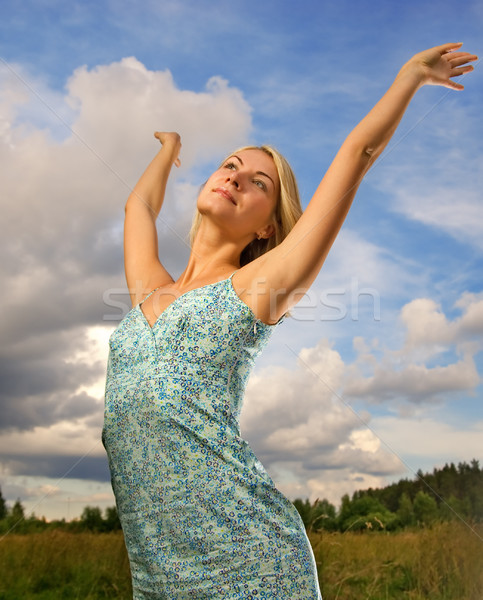 Pretty young woman over blue cloudy sky Stock photo © Nejron