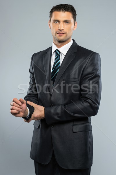 Stock photo: Well-dressed handsome man in black suit and tie 