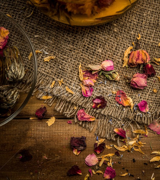 Flower tea petals on sackcloth over wooden background Stock photo © Nejron