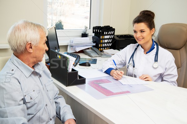 Senior om birou numire hârtie medic Imagine de stoc © Nejron