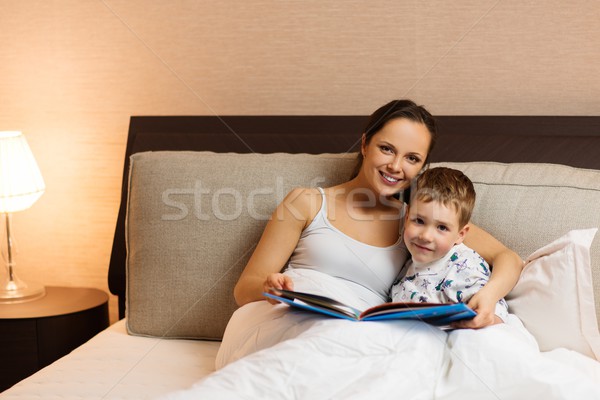Young mother and her son reading book in a bed  Stock photo © Nejron