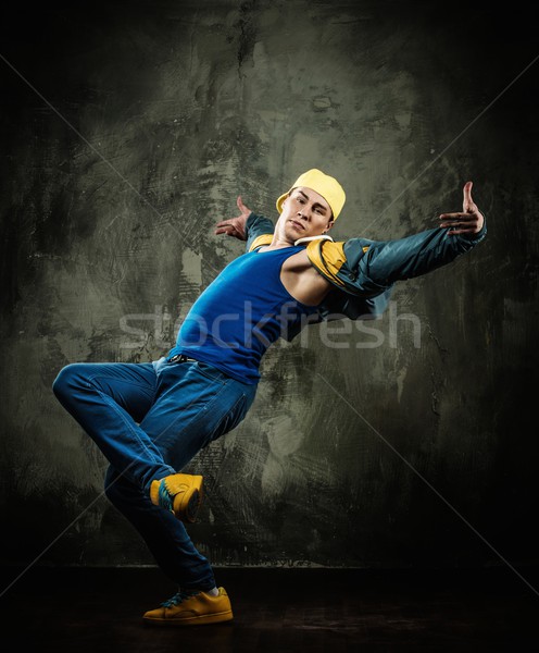 Man dancer in cap and jacket showing break-dancing moves Stock photo © Nejron