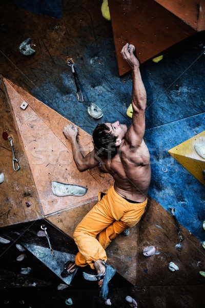 Muscular man practicing rock-climbing on a rock wall indoors  Stock photo © Nejron