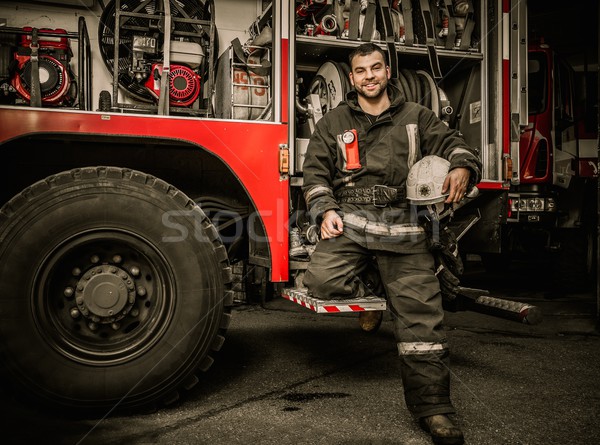 Cheerful firefighter near truck with equipment  Stock photo © Nejron