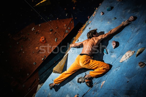 Muscular man practicing rock-climbing on a rock wall indoors  Stock photo © Nejron